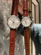Analog wristwatches with white dials and brown leather straps, side view