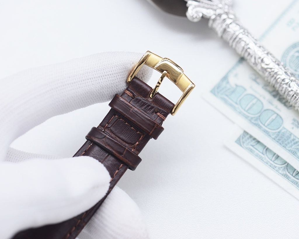 Longines leather watch strap close-up with gold-tone buckle, brown leather