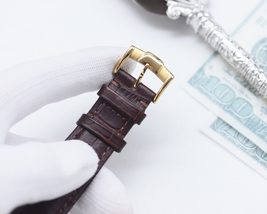 Longines leather watch strap close-up with gold-tone buckle, brown leather
