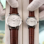 Longines quartz watch with silver case and brown leather strap, white dial