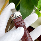 Longines watch with brown leather strap and silver buckle clasp, case profile.