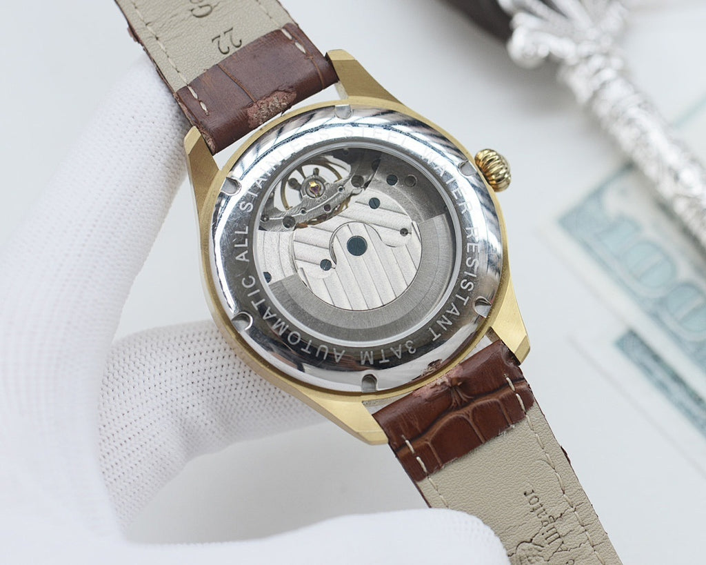 Longines watch case back, gold tone with brown leather strap, visible mechanical movement