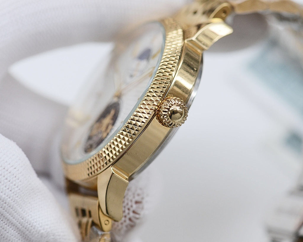Gold-tone Longines wristwatch side profile with crown and textured case