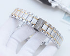 Two-tone stainless steel bracelet with gold links and clasp, on white glove