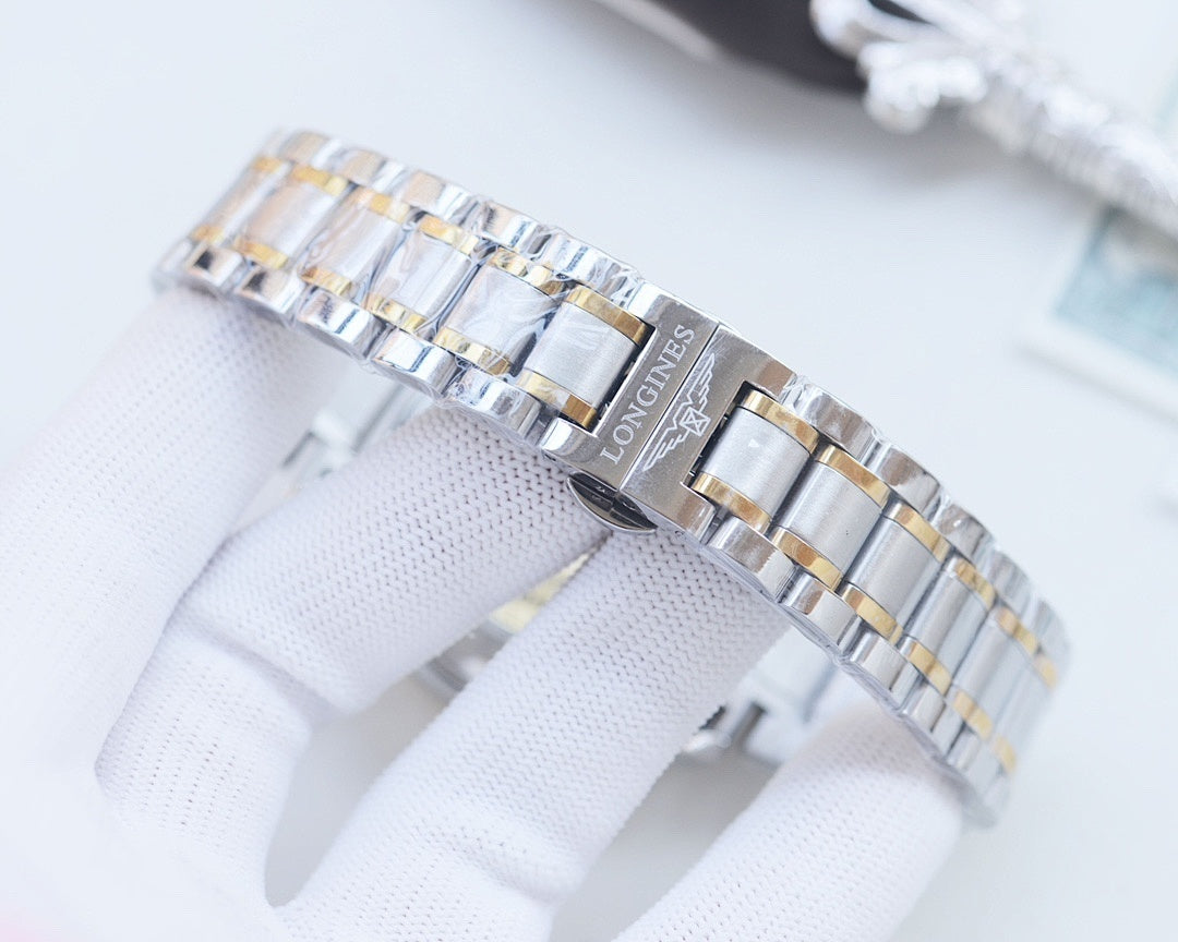 Two-tone stainless steel bracelet with gold links and clasp, on white glove