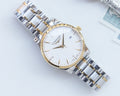 Two-tone stainless steel wristwatch with white dial and gold accents, three-hand