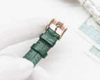 Longines watch with green leather strap and metal clasp, viewed from the side