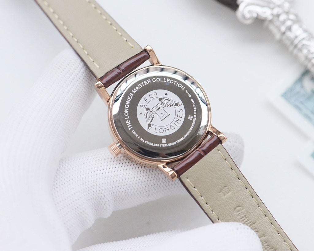 Longines watch back case on light brown leather strap, circular engraved medallion