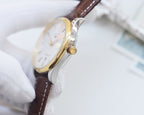 Gold-tone watch case with brown leather strap and crown close-up, white dial.