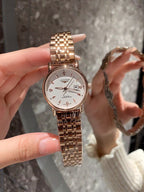 Longines rose-gold tone wrist watch with white dial, metal bracelet, date window visible