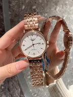 Longines rose-gold tone wrist watch with white dial and metal bracelet, side profile view