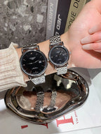Longines wrist watches with black dials and silver metal bracelets, two watches side by side