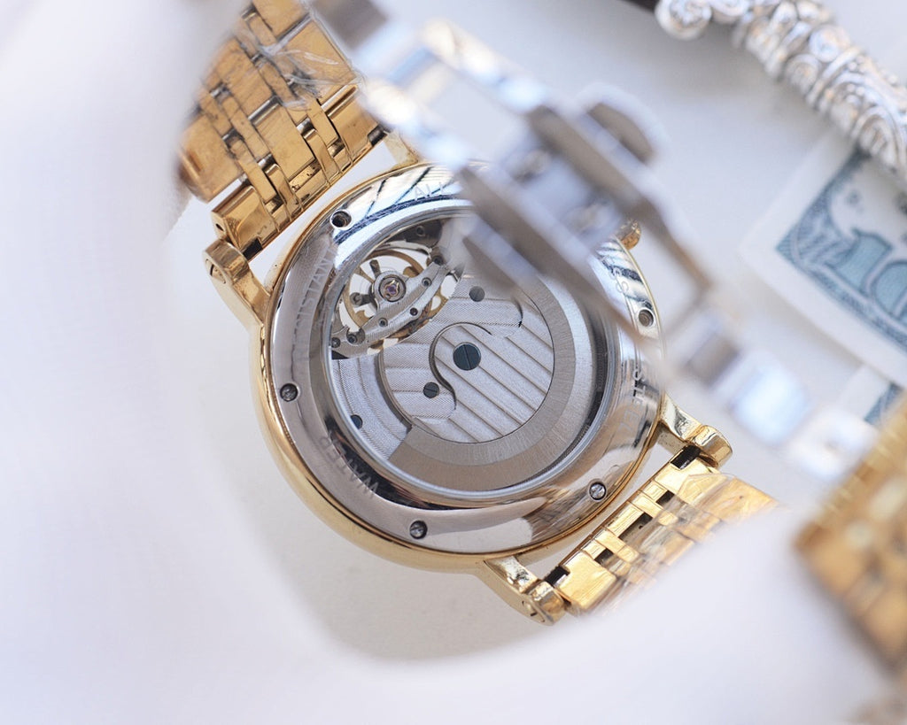 Gold-tone metal watch case with exposed mechanical movement view