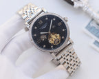 Silver-tone metal watch with dark blue dial, diamond bezel, and skeleton movement