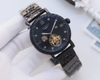Black metal watch with dark blue dial and visible skeleton movement
