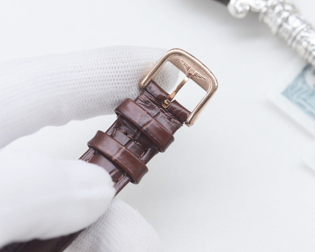 Longines watch, brown leather strap with buckle, underside visible.