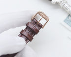 Longines watch, brown leather strap with buckle, underside visible.