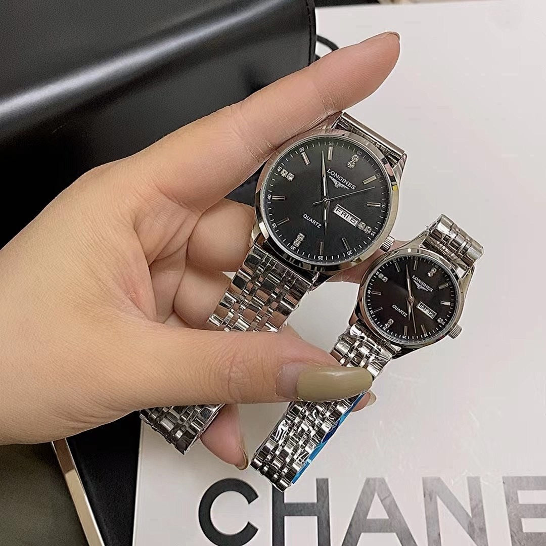 Longines watch pair held in hand, black dial with silver metal bracelets