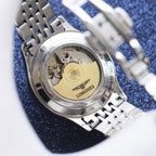 Longines watch case back with visible movement and stainless steel bracelet