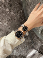 Longines watch with dark dial and silver metal bracelet on a wrist, paired with another watch
