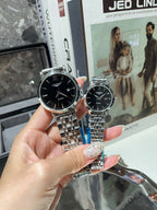 Longines watch with dark dial and silver metal bracelet, close view on a hand