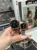 Longines watch with dark dial and silver metal bracelet, shown held in a hand