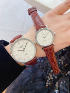 Longines wristwatch pair with white dials and red-brown leather straps, round silver cases