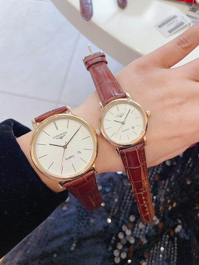 Longines wristwatch pair with white dials and red-brown leather straps, rose gold-tone cases