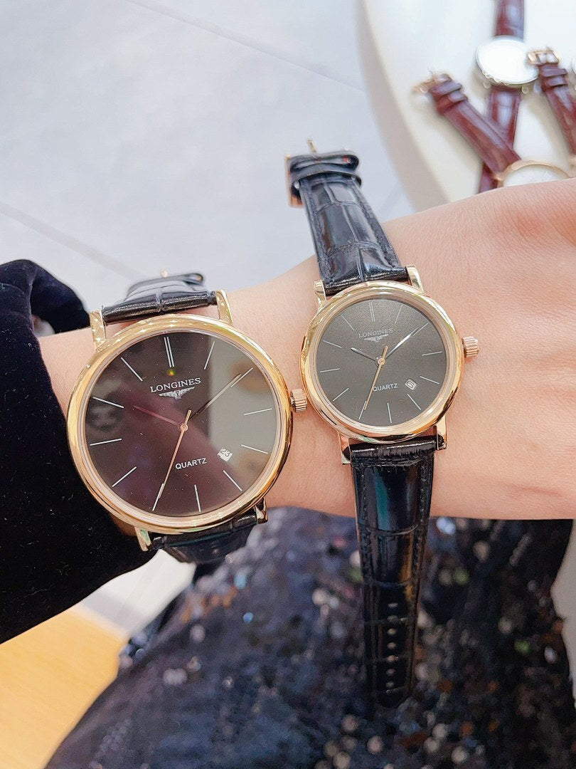 Longines wristwatch pair with dark dials and black leather straps, round gold-tone cases