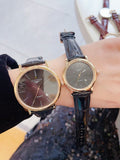 Longines wristwatch pair with dark dials and black leather straps, round gold-tone cases