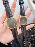 Longines wristwatch pair with dark dials and black leather straps, gold-tone round cases