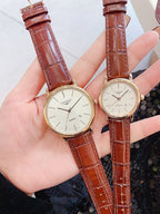 Longines wristwatch pair with white dials and rust-brown leather straps, gold-tone round cases
