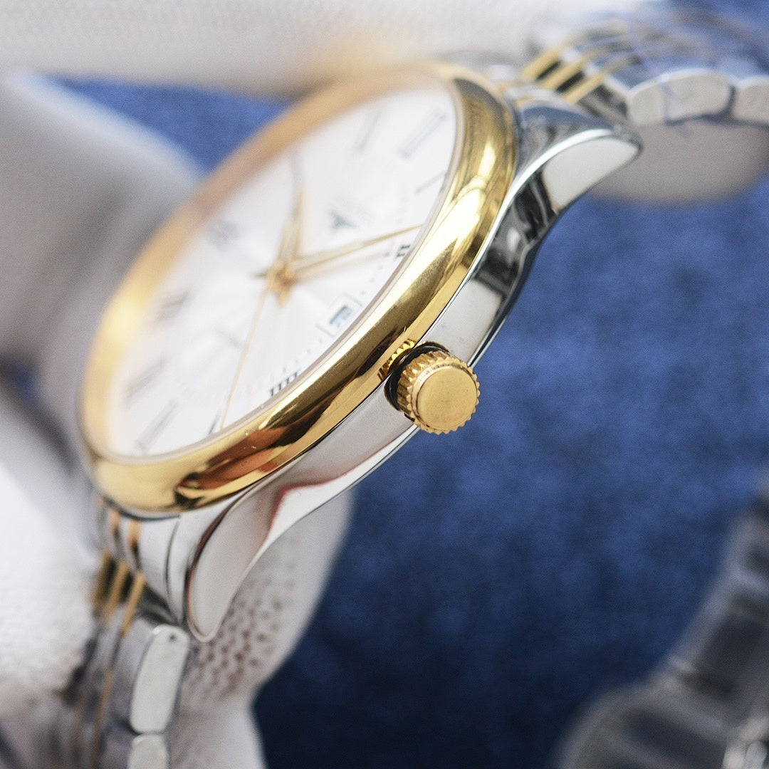 Two-tone watch crown and gold-toned knob on the side of a stainless steel case
