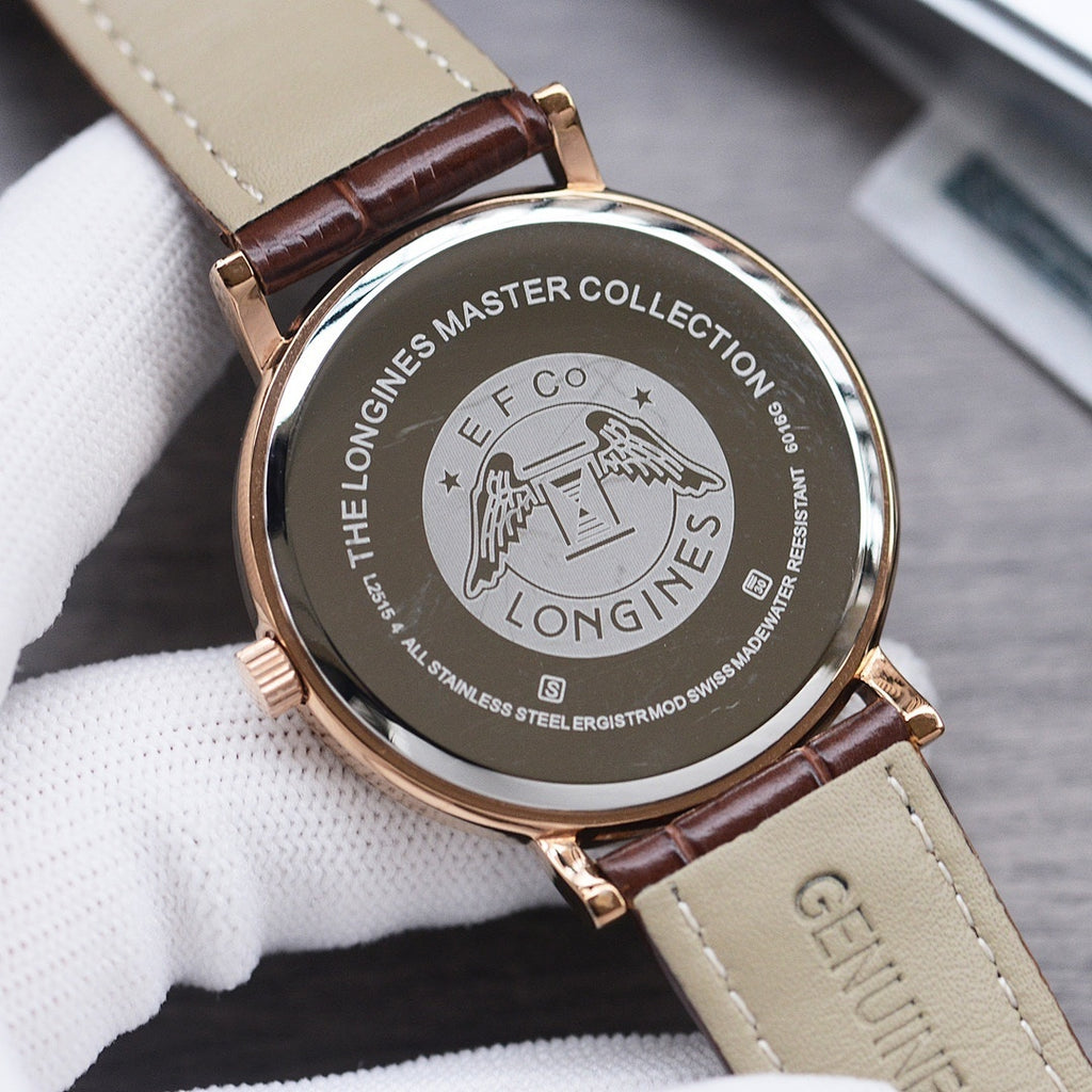 Longines watch case back with engraving, gold-tone case, brown leather strap, clasp visible.