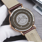 Longines watch case back with engraving, gold-tone case, brown leather strap, clasp visible.