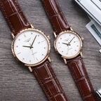 Longines watch pair with white dials, brown leather straps, gold-tone cases, quartz labels.