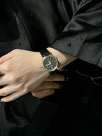 Luxury wrist watch with dark dial and black leather strap on a wrist