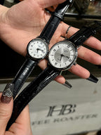 Pair of luxury wrist watches with black leather straps and silver-tone faces