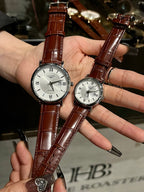 Pair of luxury wrist watches with brown leather straps and silver-tone dials
