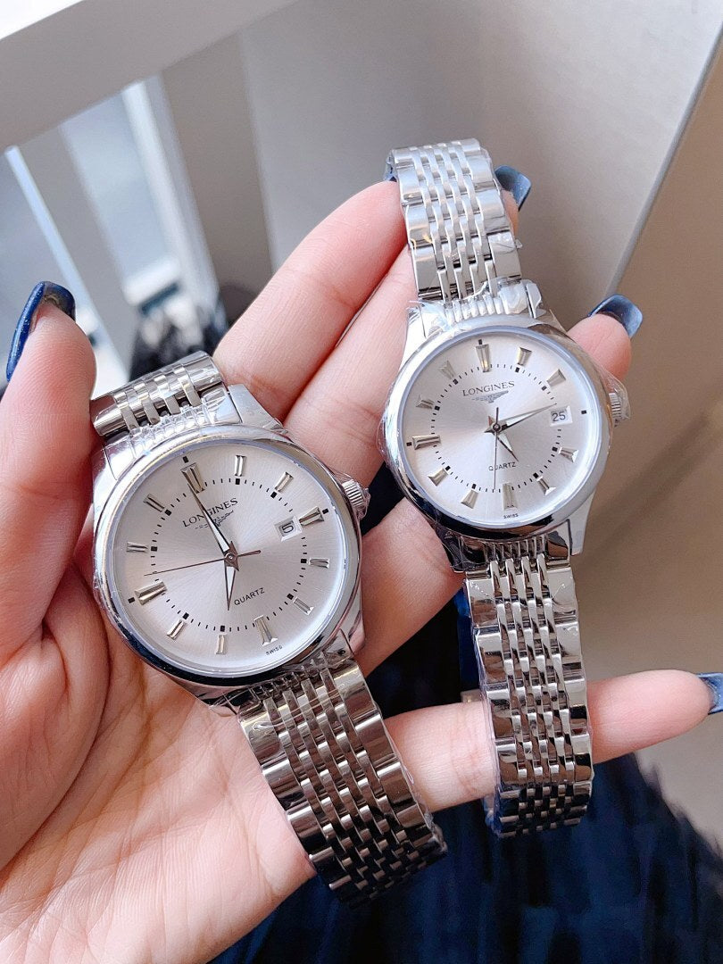 Longines wristwatch, white dial with steel link bracelet, angled close-up.
