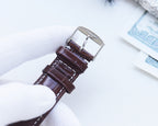 Longines wristwatch back with brown leather strap and silver buckle clasp