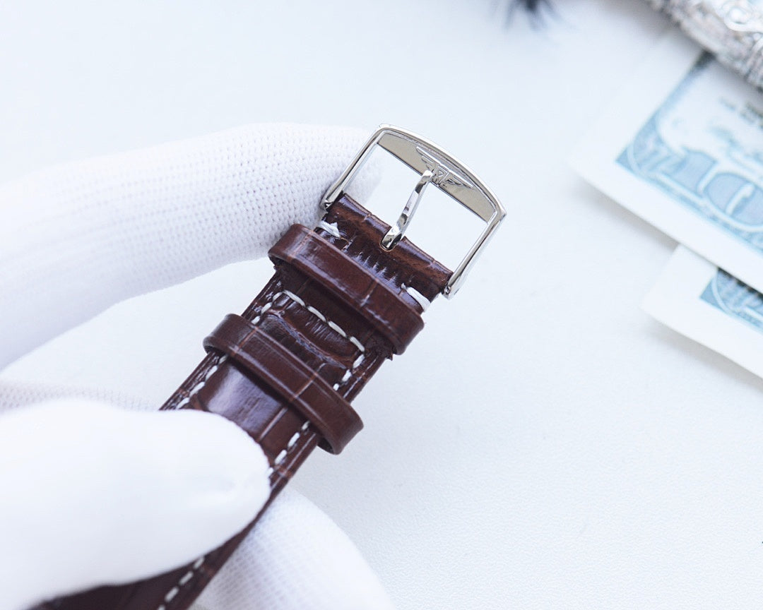 Longines wristwatch back with brown leather strap and silver buckle clasp