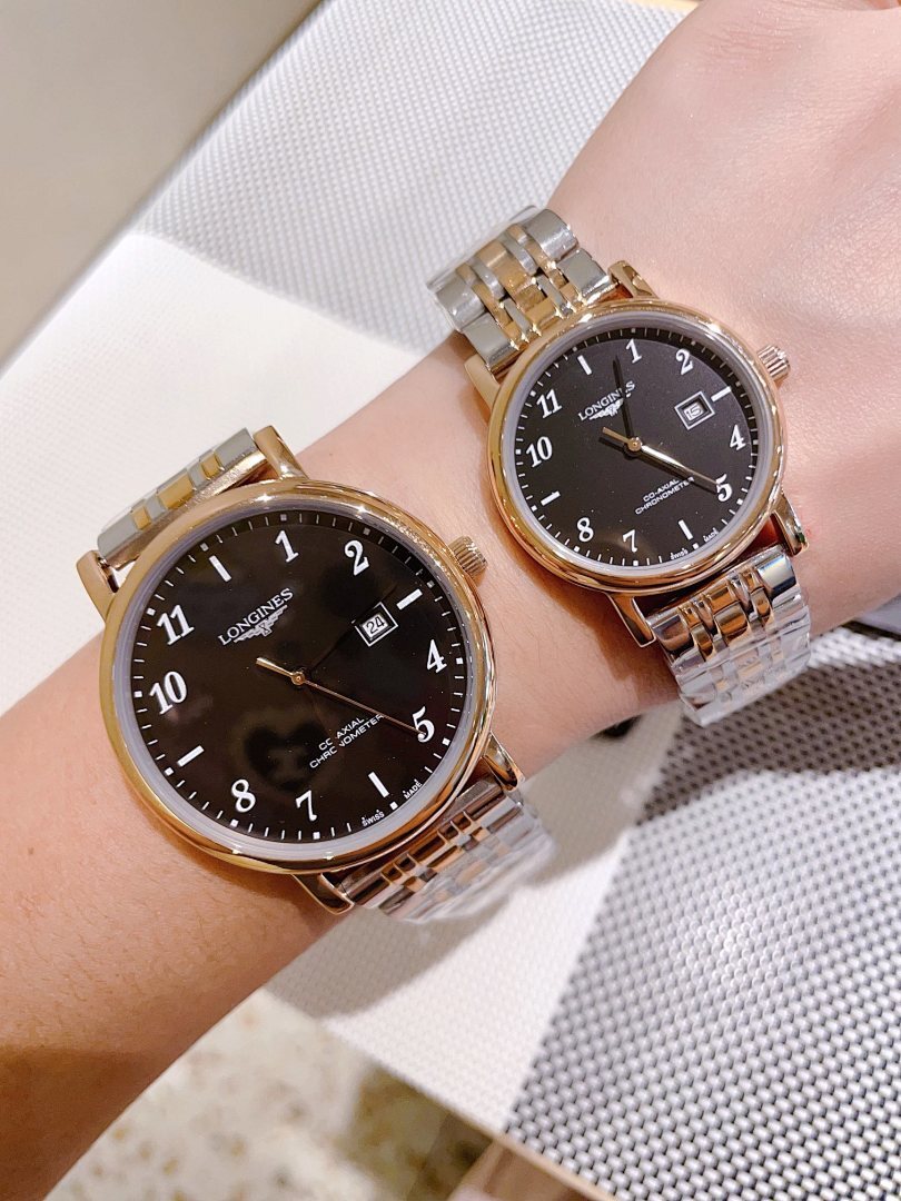 Two gold-tone and silver-tone wrist watches with black dials on arm