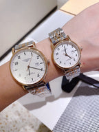 Two silver-tone wrist watches with white dials and metal link bracelets side by side