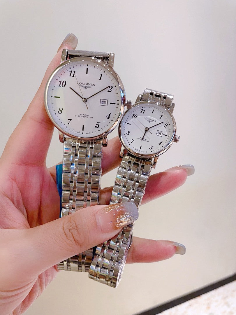 Two silver-tone wrist watches with white dials and metal link bracelets on hands