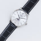 Longines watch with white dial, silver case, and black leather strap
