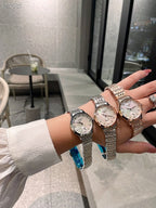 Longines watch with silver metal bracelet and blue strap detail, worn on wrist.