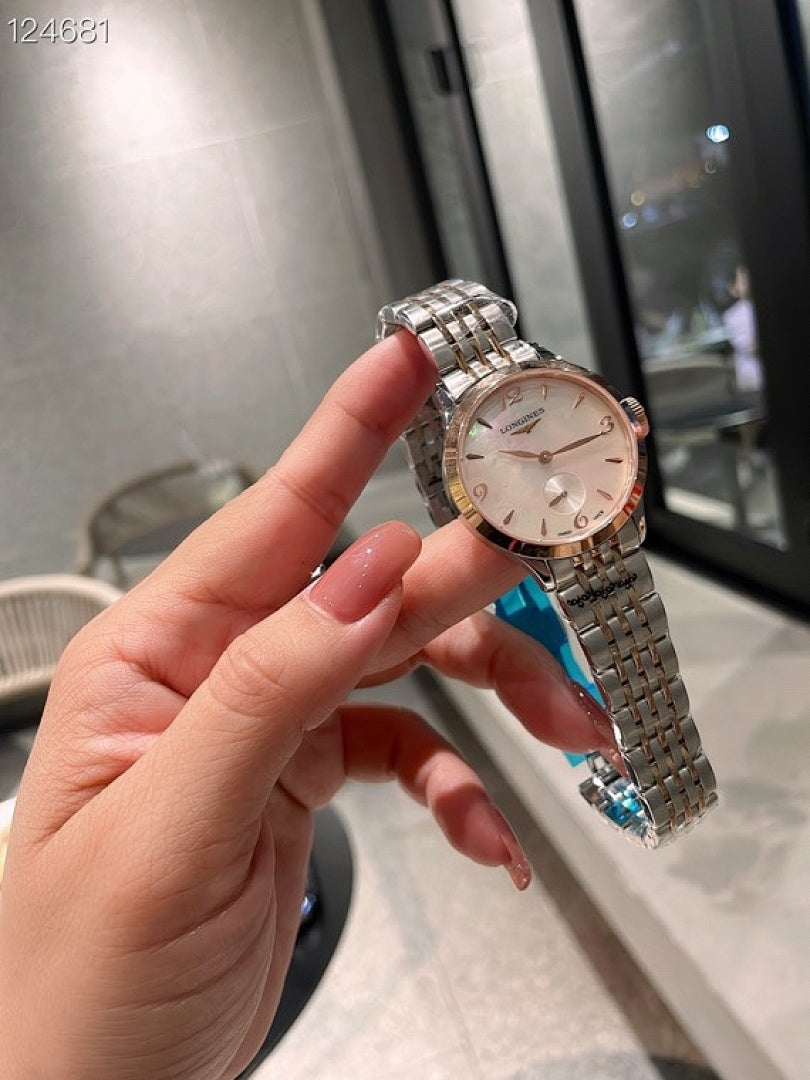 Longines watch close-up with silver metal bracelet, light dial and crown.
