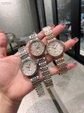 Longines watch with silver metal bracelet and light dial, worn on hand.
