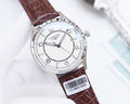 Silver analog watch with brown crocodile leather strap and white dial, crown and markers visible.